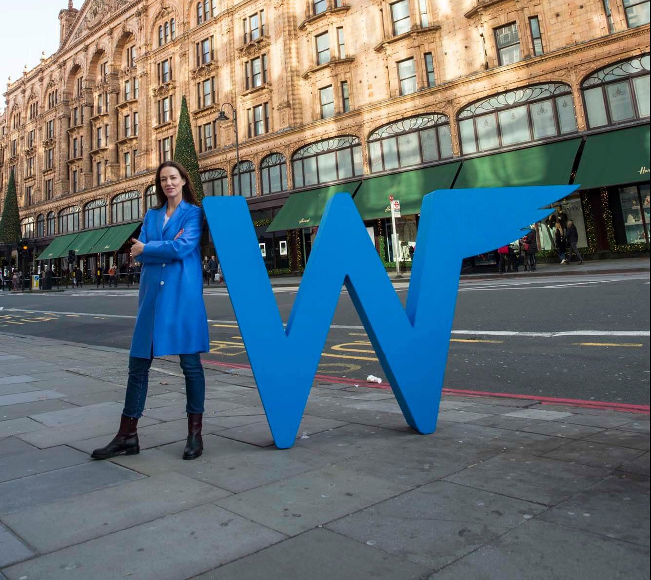Tina Wilson with big Wingman logo sign in London